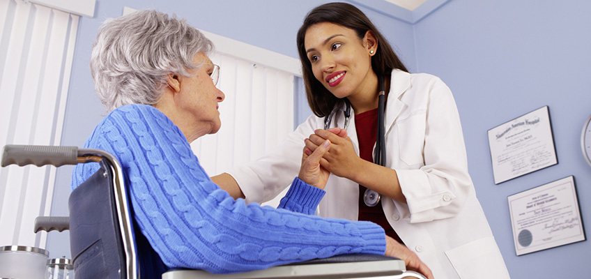 A senior and doctor holding hands.