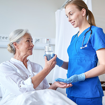 nurse helping woman with medication