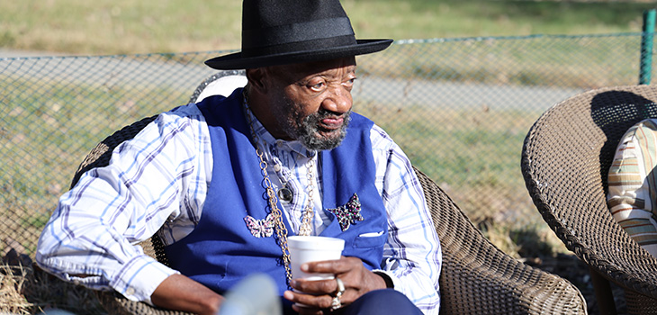 An elderly man sitting outside at an event at Douglas County.