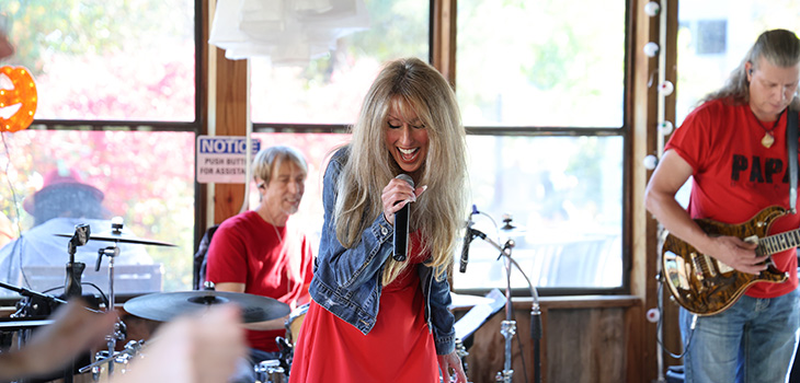 A woman singing with a band at an event at Douglas County.
