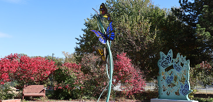 A butterfly statue and flowers at Douglas County