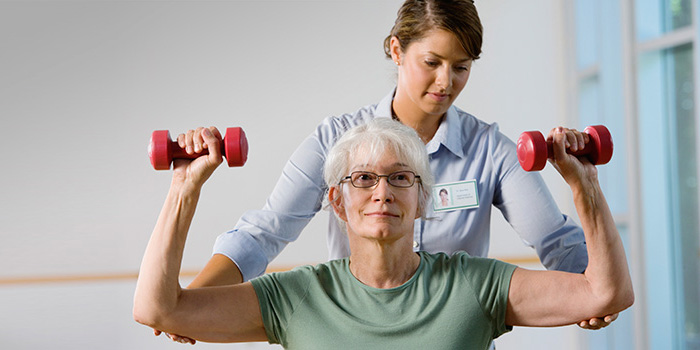 woman lifting weights with help