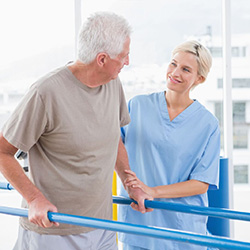 nurse helping man with physical therapy