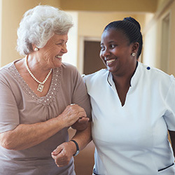 nurse walking with woman in hallway