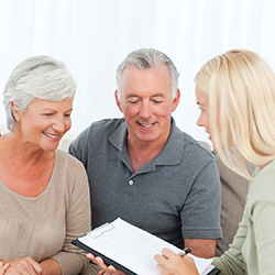 couple being aided by a woman with a clipboard