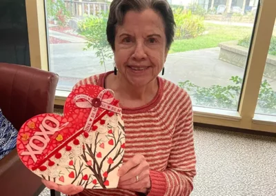 A resident shows off a Valentine's Day heart she decorated with paint and embellishments.