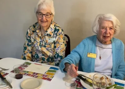 Residents sit together, enjoying a meal.
