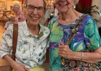 Two residents in brightly colored floral shirts stand together.