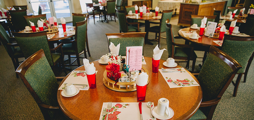 Resident dining room with place settings and clean floors