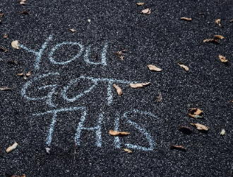 Chalk written on the road that reads You Got This.