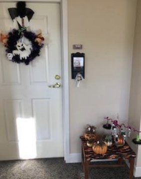 A resident apartment with halloween decorations in front of the door.