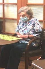 A Resident With A Mask On Playing A Table Game