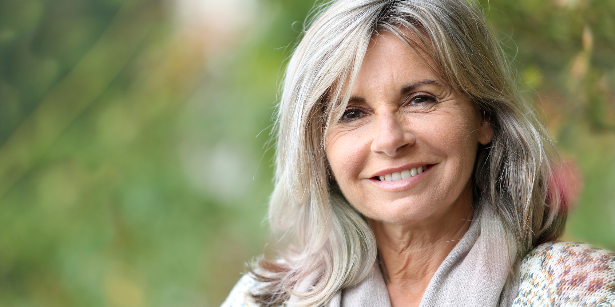 A senior woman smiling outside.