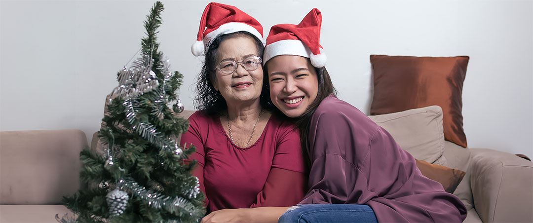 two women enjoying the holiday season with a little tree and hats