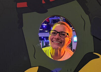 A woman smiling behind a pickle cutout