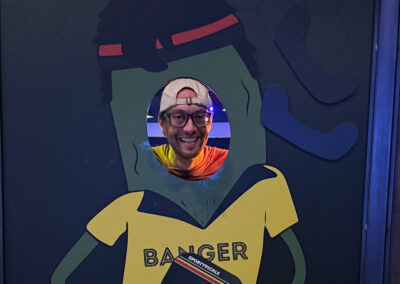 An employee smiling behind a pickle cutout