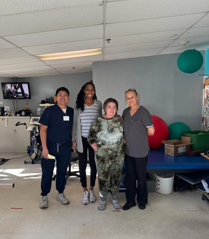 Melanie and therapists in the Lowry Hills rehab gym