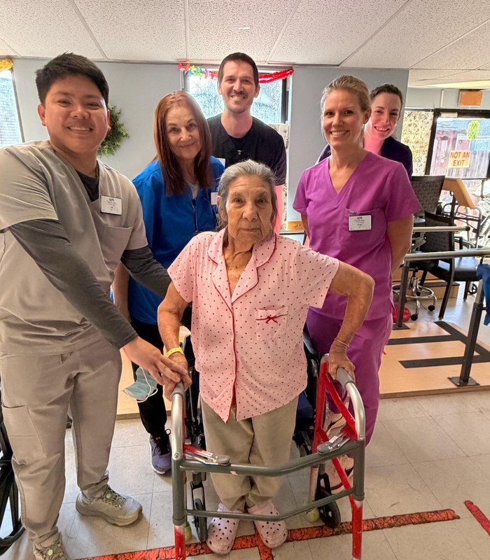 Natalia in the therapy gym with members of the therapy team.