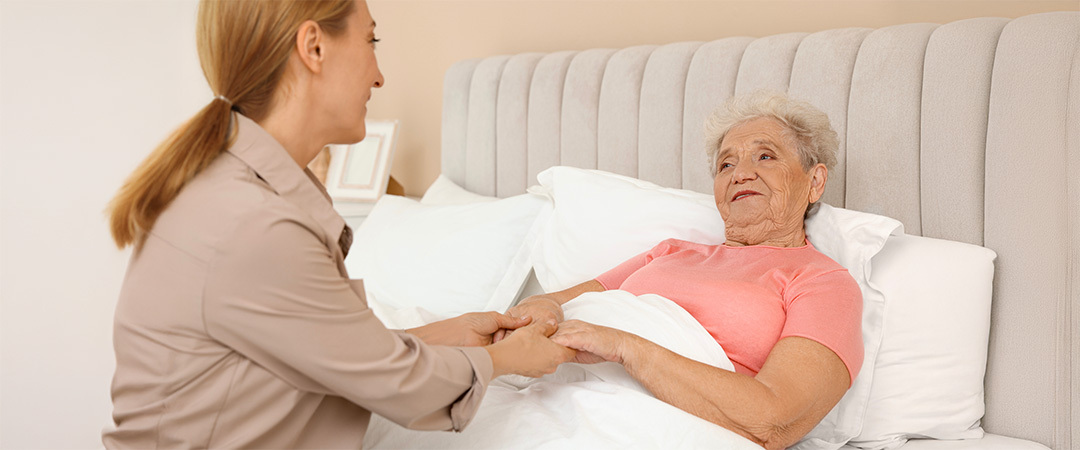 a woman in a hospice bed practicing pressure injury prevention 