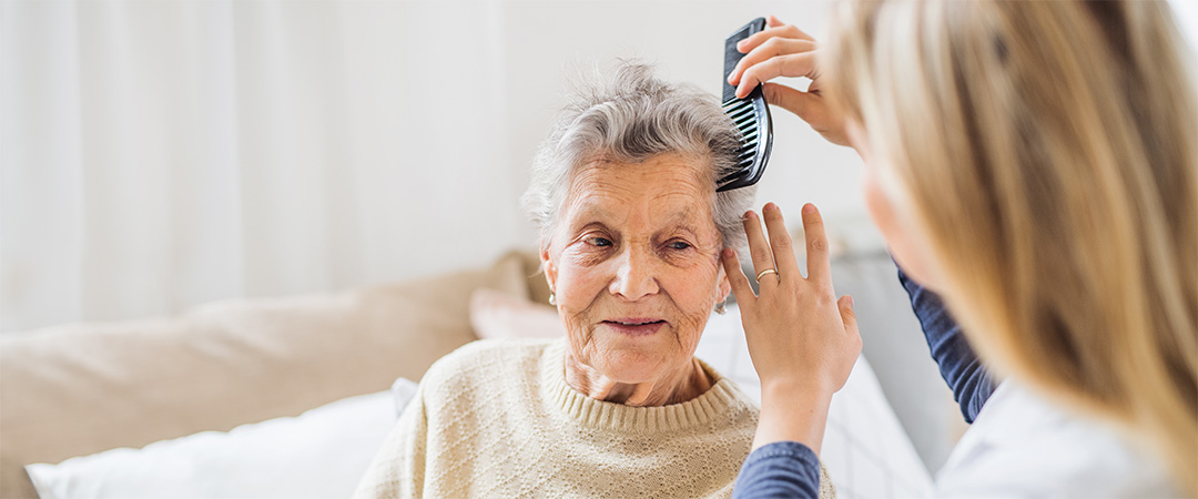 brushing a woman's hair Assisted Living vs In Home Care