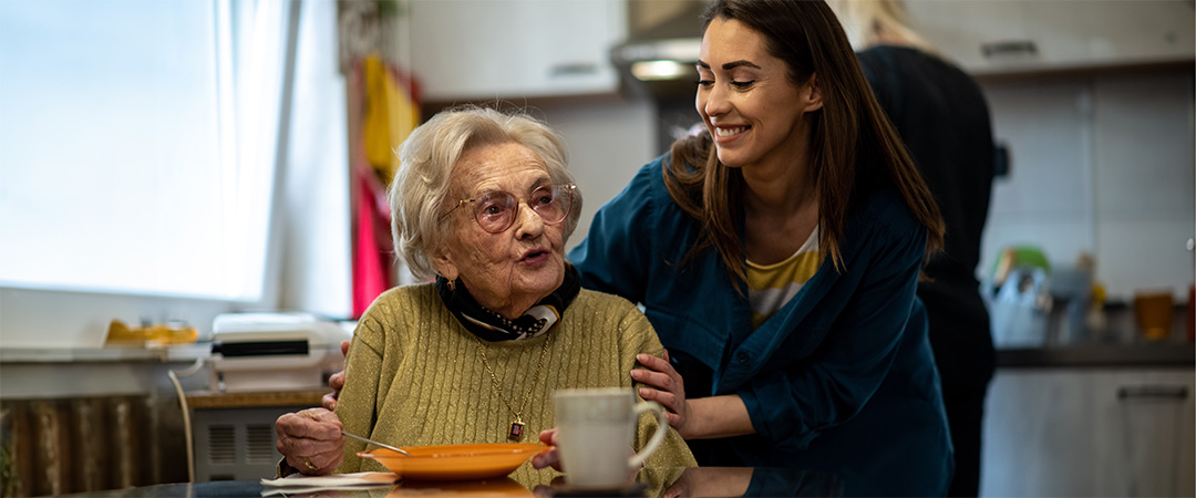 Caregiver talking with senior woman about infection prevention