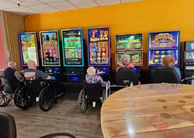 Five people in wheelchairs playing slot machines