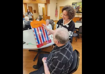 Man playing a game called Pumpkin Drop in a common room with other residents