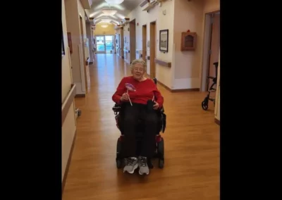 Woman in a red shirt in a wheelchair in a hallway