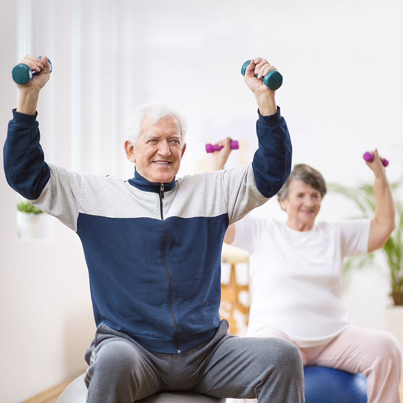 Residents in a seated chair yoga class