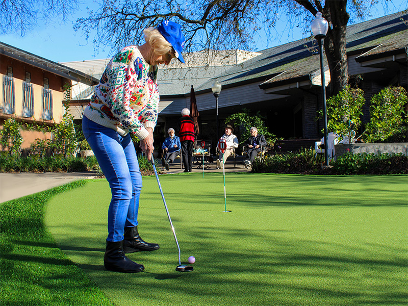 Elderly woman putting on the green