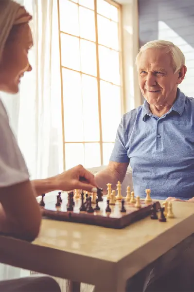 Woman and man playing chess and smiling.