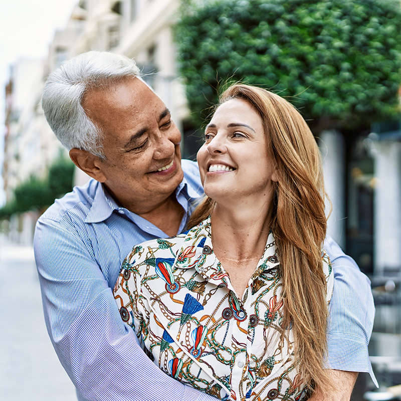 A mature couple smiling at each other.