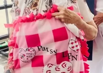 Woman holding a pink quilt.