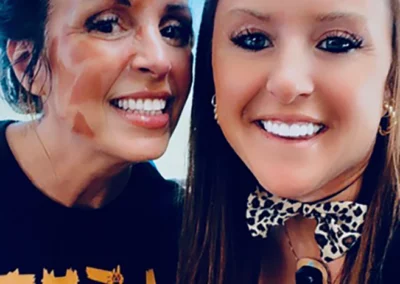 Two staff members take a selfie with an animal ear filter