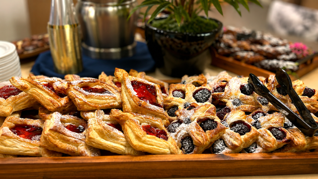 A plate of pastries nicely lined on a wood serving tray.