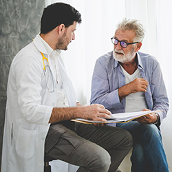 A doctor speaking with a senior in a room.