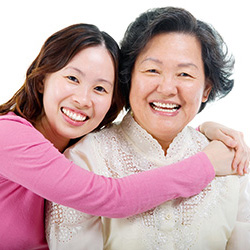 A mother and daughter smiling and hugging each other.