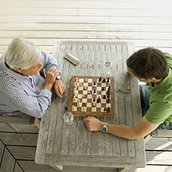 A senior and a young man playing a game of chess.