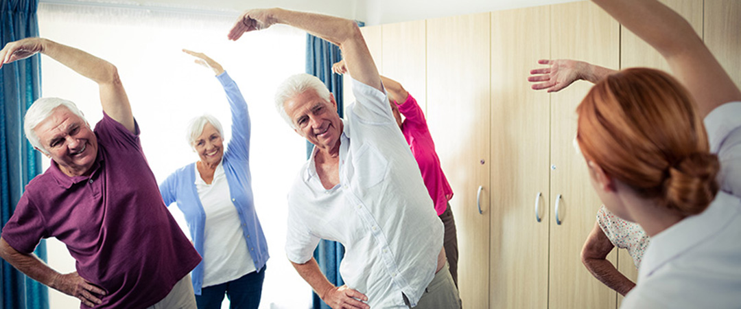 A group of seniors performing exercises together in a room.