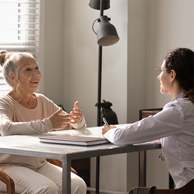 An elderly woman talking to an older woman
