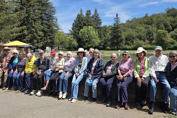 A group of independent living residents on an outing sitting by a lake