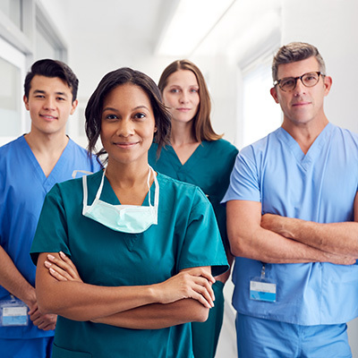 A group of nurses standing in a row smiling.