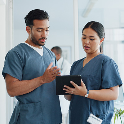 Two nurses looking at a patient file together.