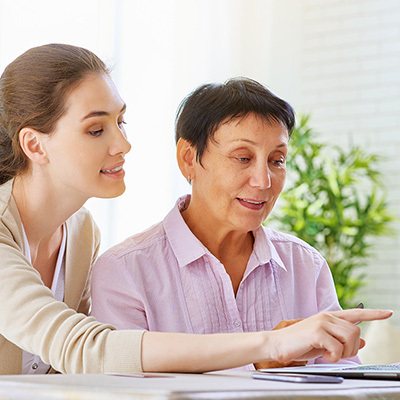 A mother and daughter looking at a laptop together.
