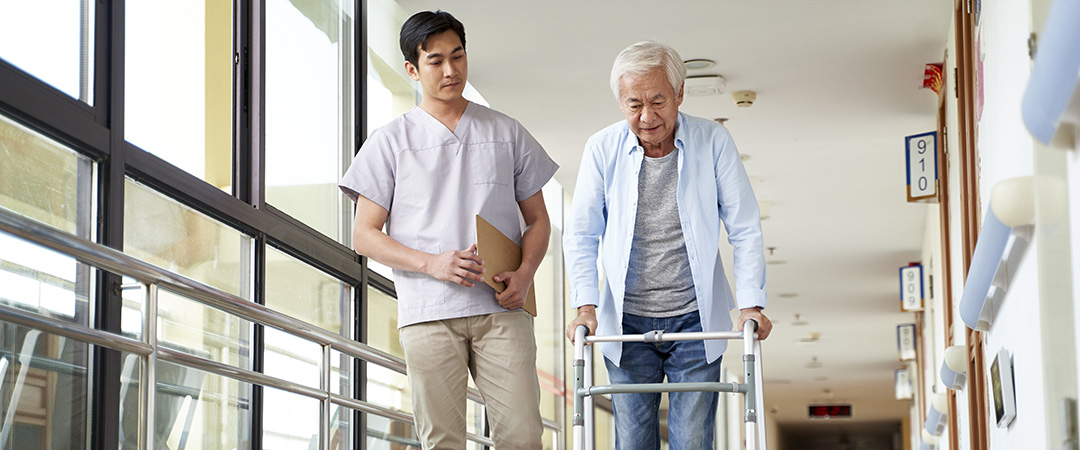 Elderly Man Being Assisted by Male Nurse