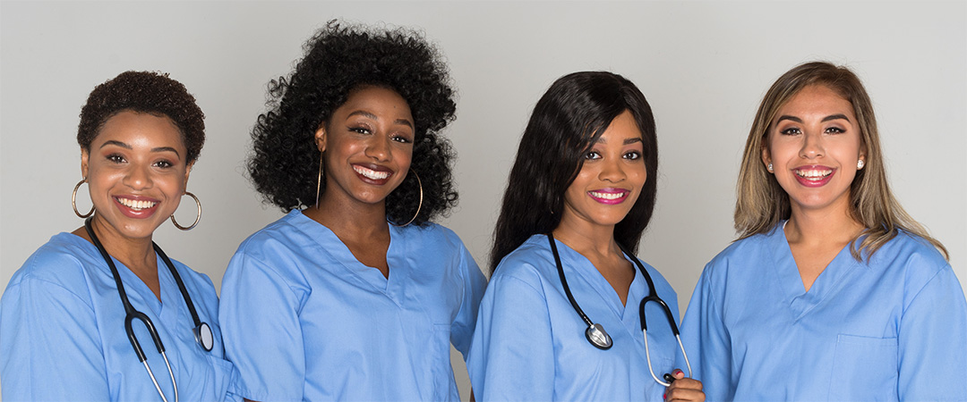 Four women in blue scrubs