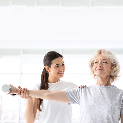 Physical therapist assisting a resident on shoulder exercises