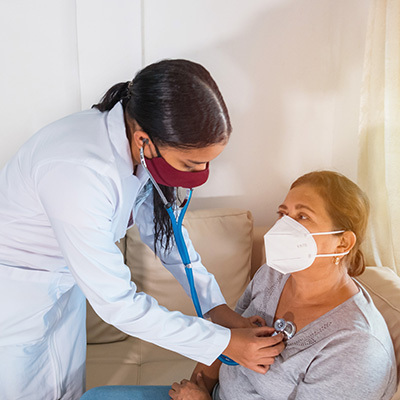 Nurse and patient wearing mask, nurse is taking vitals