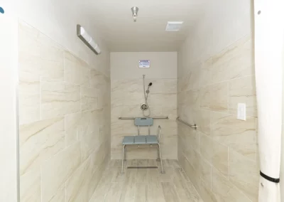 A walk in shower with detachable shower head and shower chair