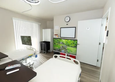 A patient room with two beds and a large window